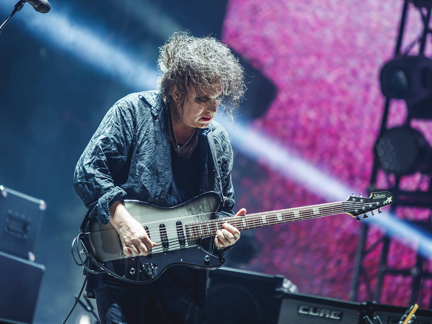 Robert Smith of The Cure playing his signature Schecter Ultracure by Javier Bragado/WireImage via Getty Images