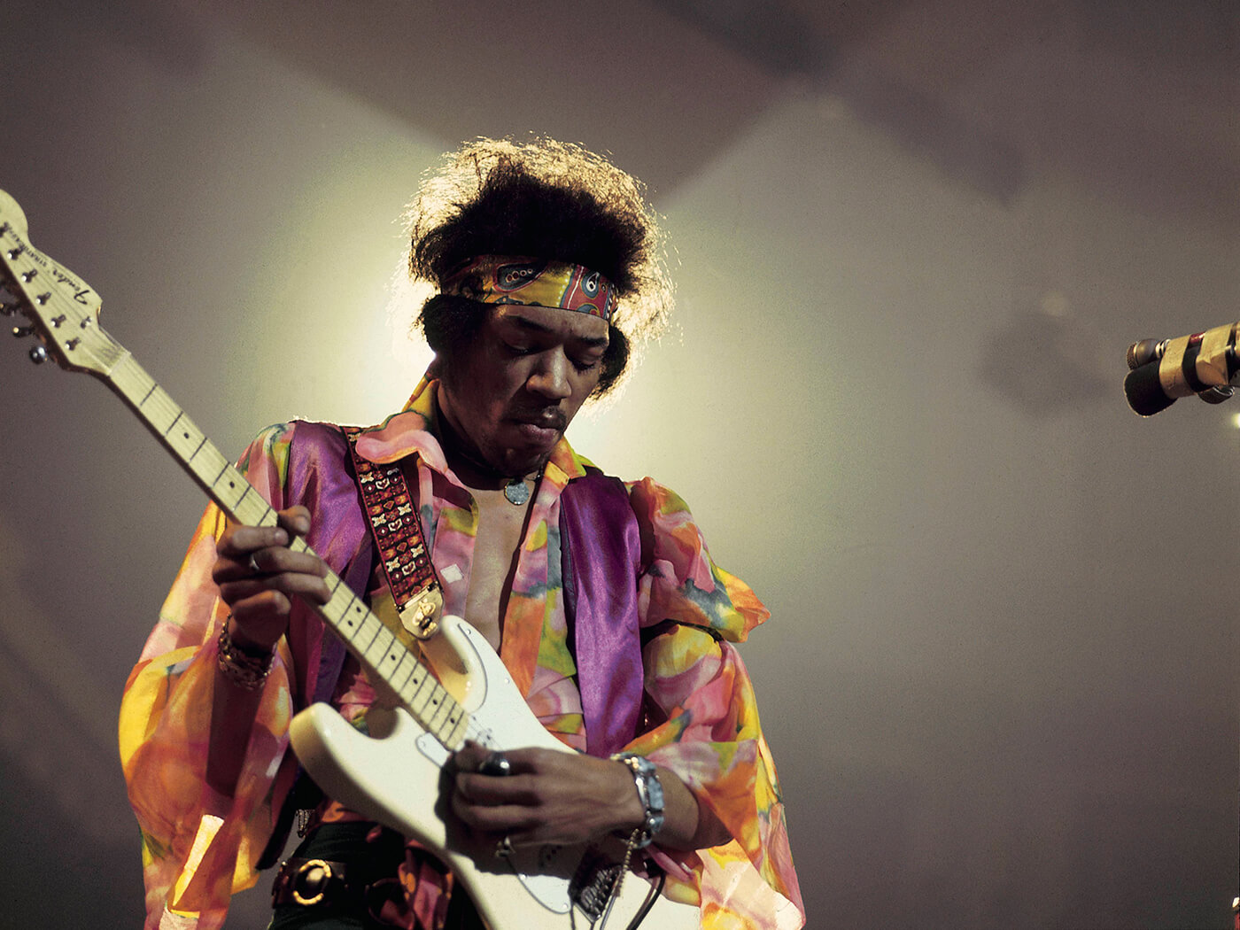 Jimi Hendrix playing a white Fender Stratocaster on stage