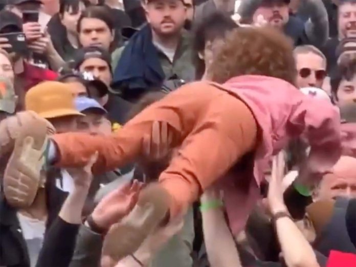Young girl crowd surfing at gig