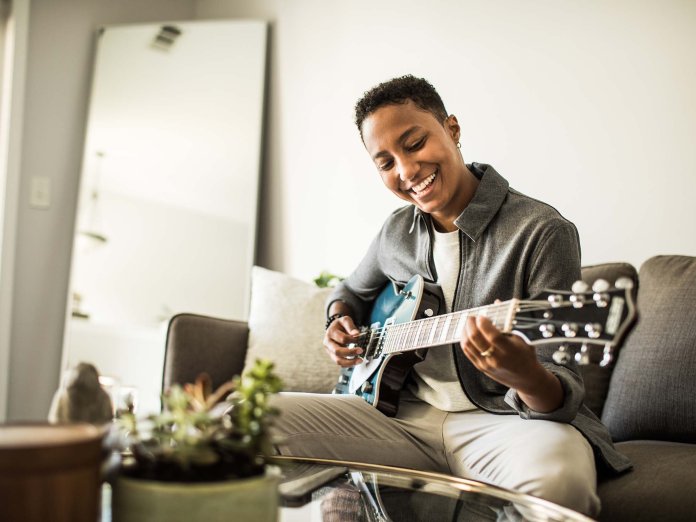 woman-playing-guitar-in-living-room@2000x1500