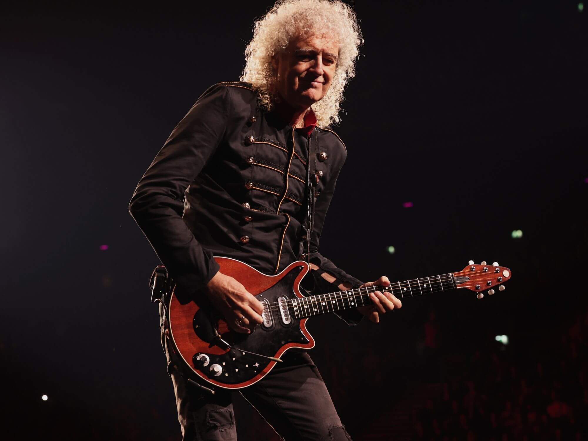 Brian May performing onstage in 2022