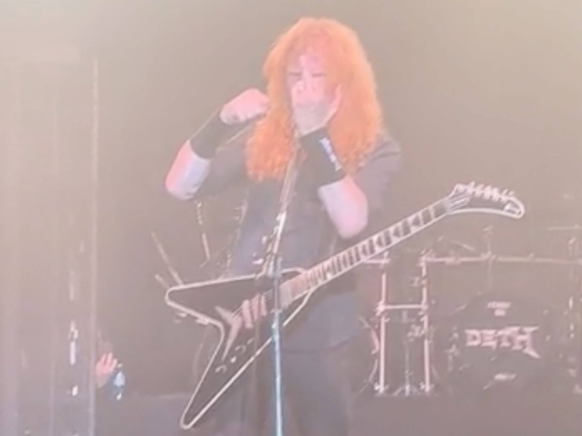 Dave Mustaine giving a middle finger while onstage