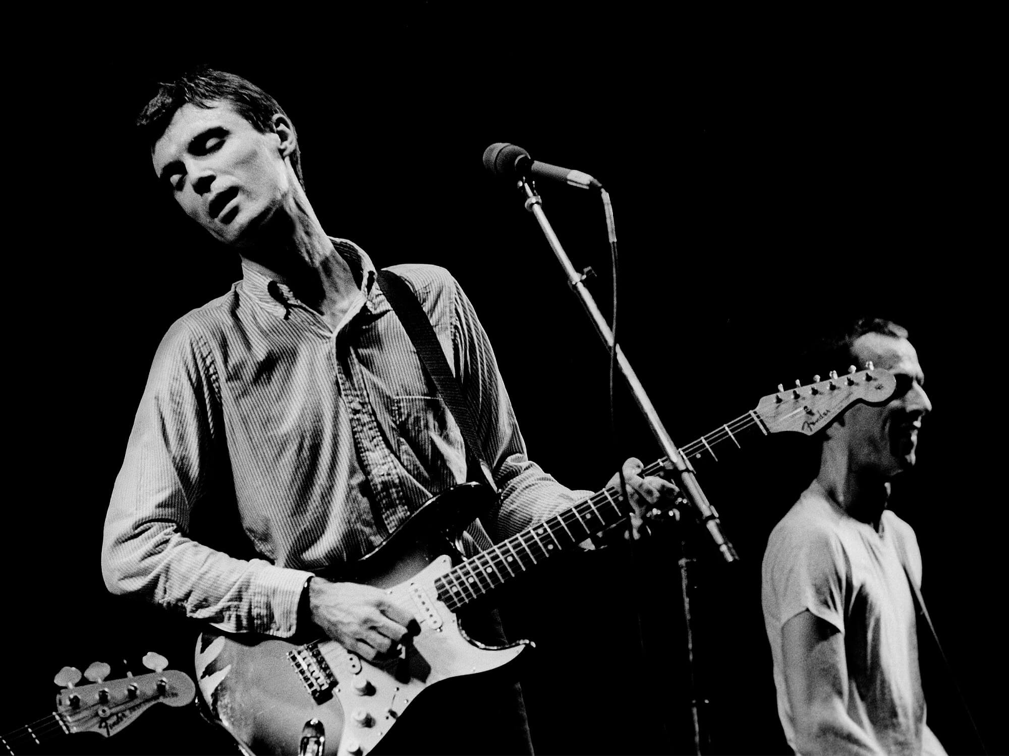 David Byrne on stage in 1980, playing a Stratocaster.