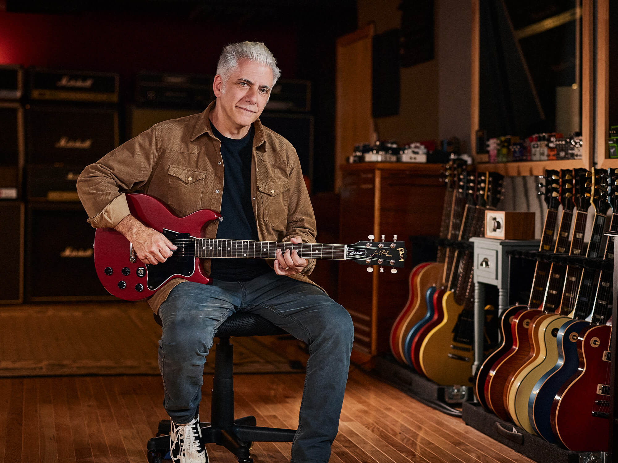 Rick Beato sitting down holding his Burgundy Les Paul Special. He's looking directly at the camera with a slight smile.