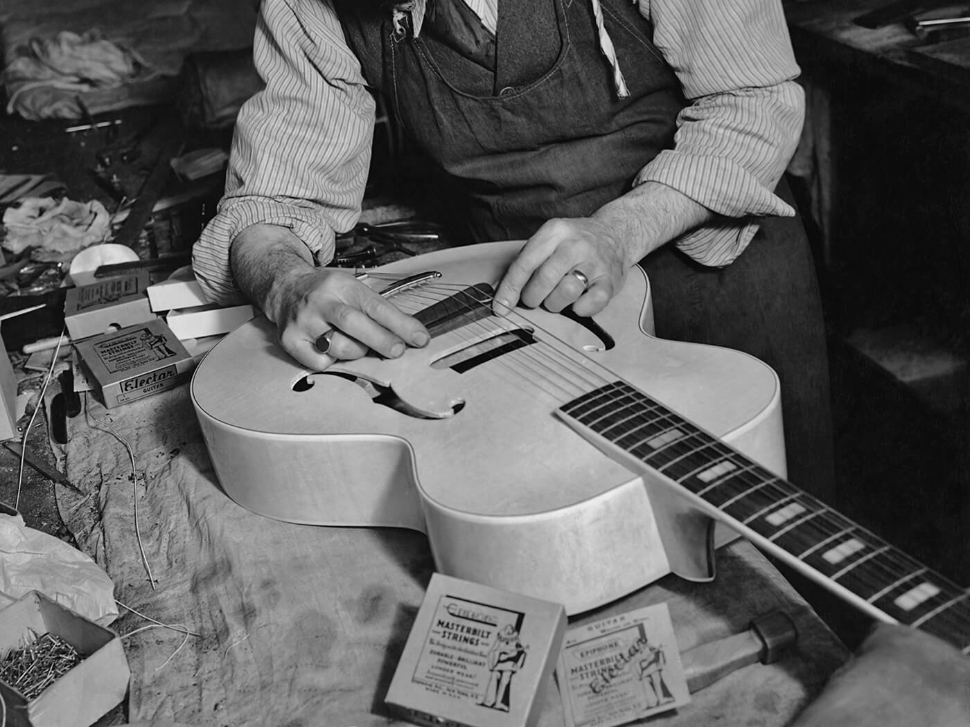 A man fitting the bridge to an Epiphone electric guitar in 1940 by FPG/Getty Images