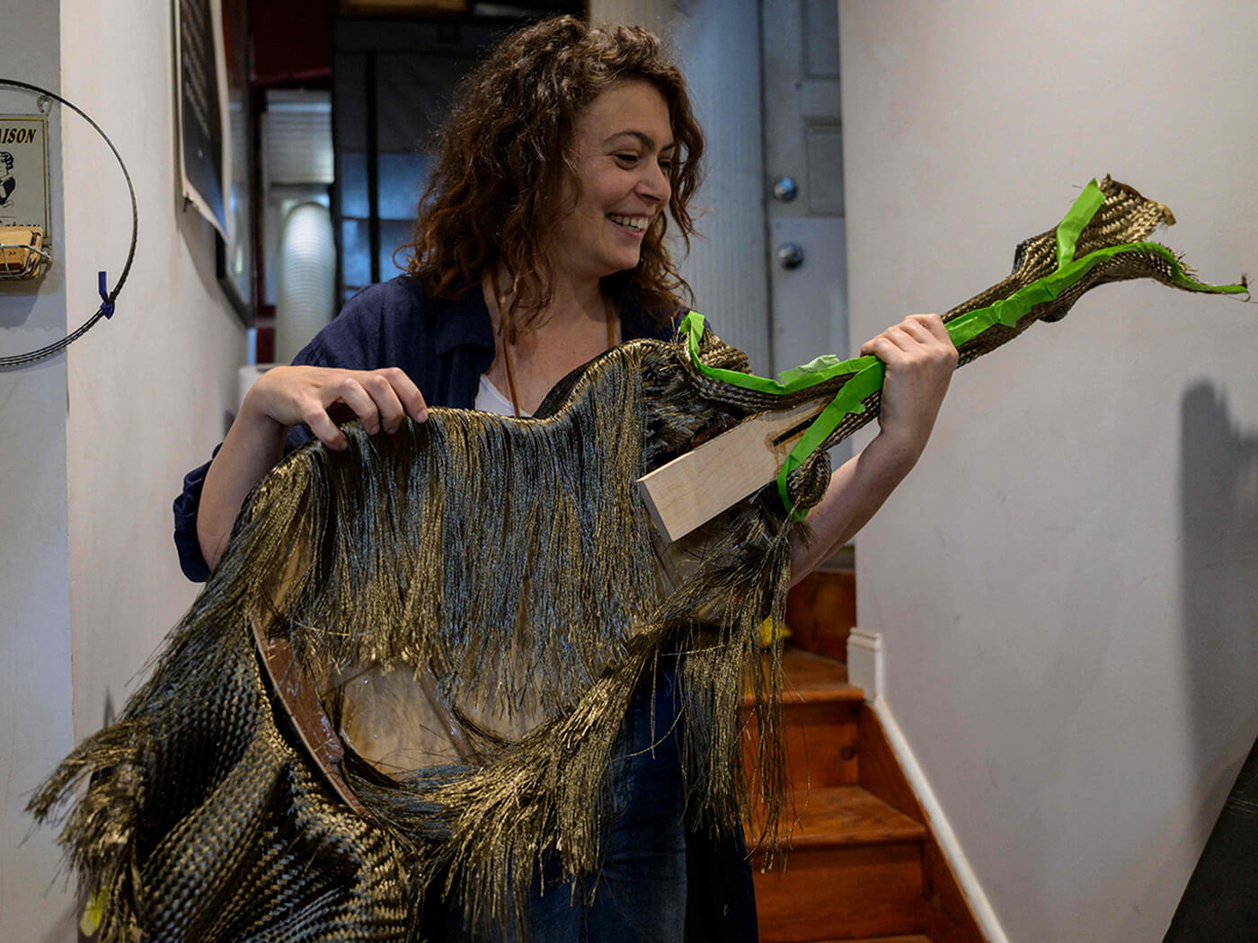 Rachel Rosenkrantz holding up a guitar body made using basalt fibers
