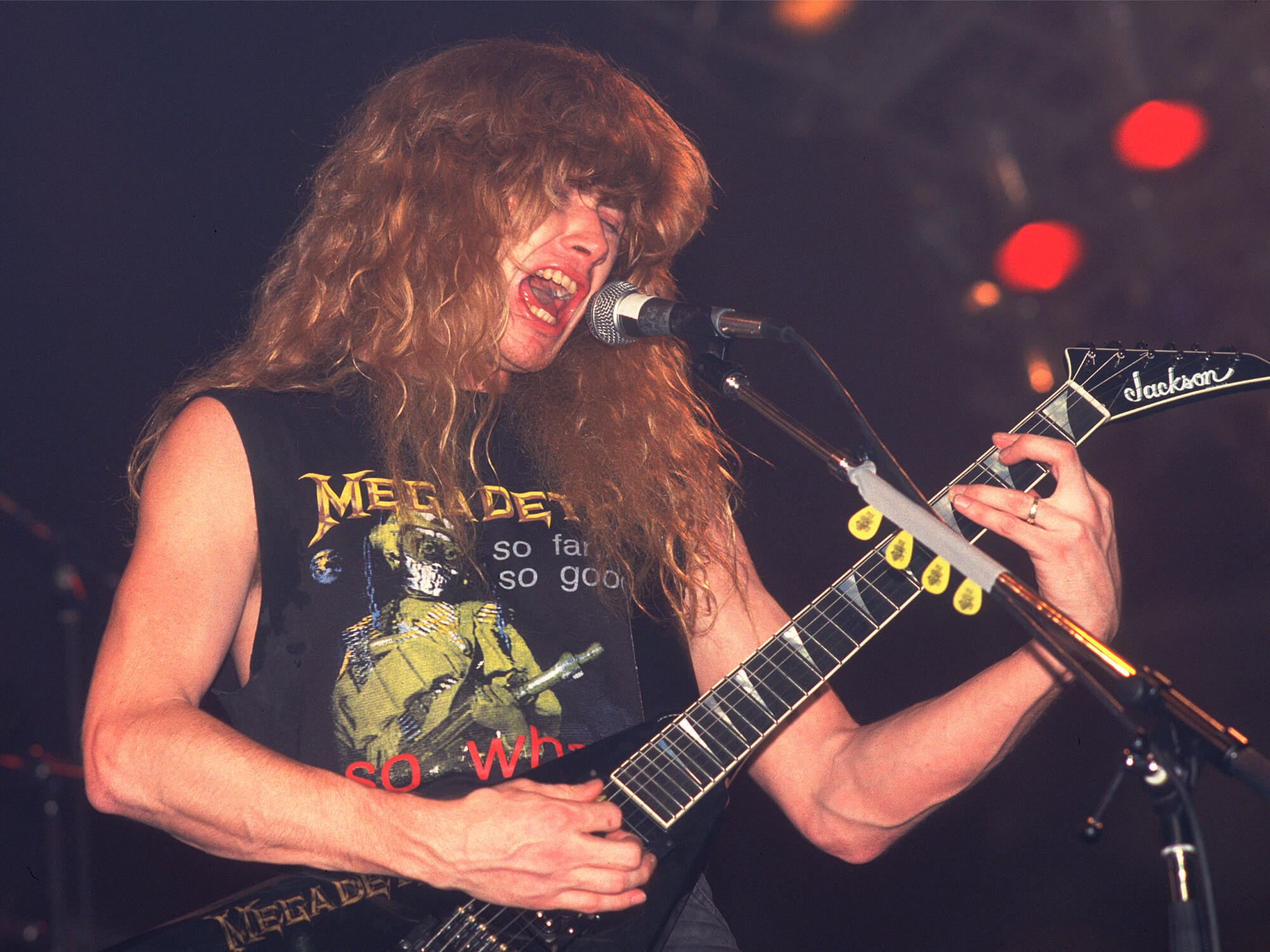 Dave Mustaine in 1988, he's singing into a mic and playing a Jackson electric guitar