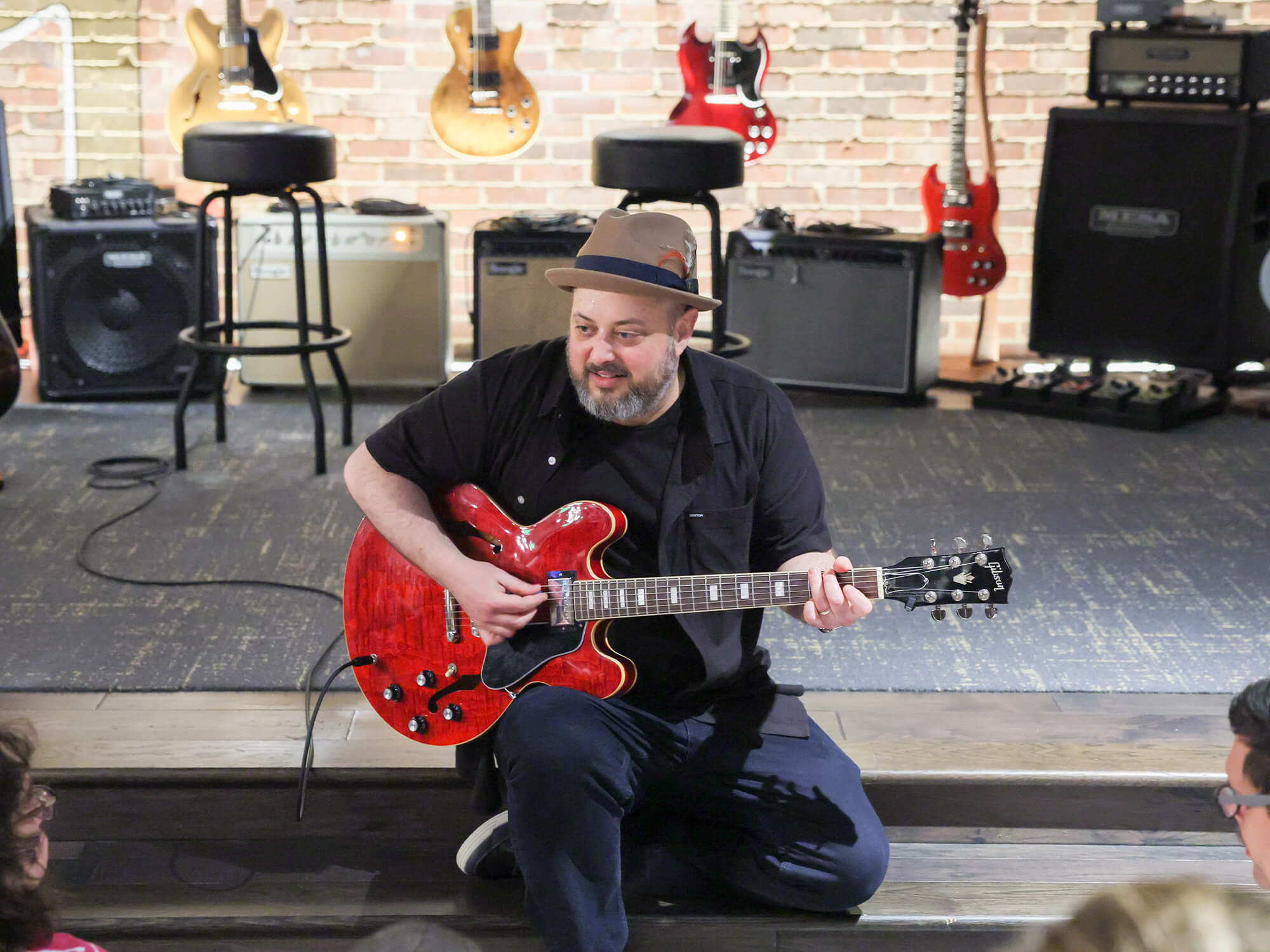 Marty Schwartz with his red Epiphone. He's sitting on some steps and appears to be teaching a small crowd.