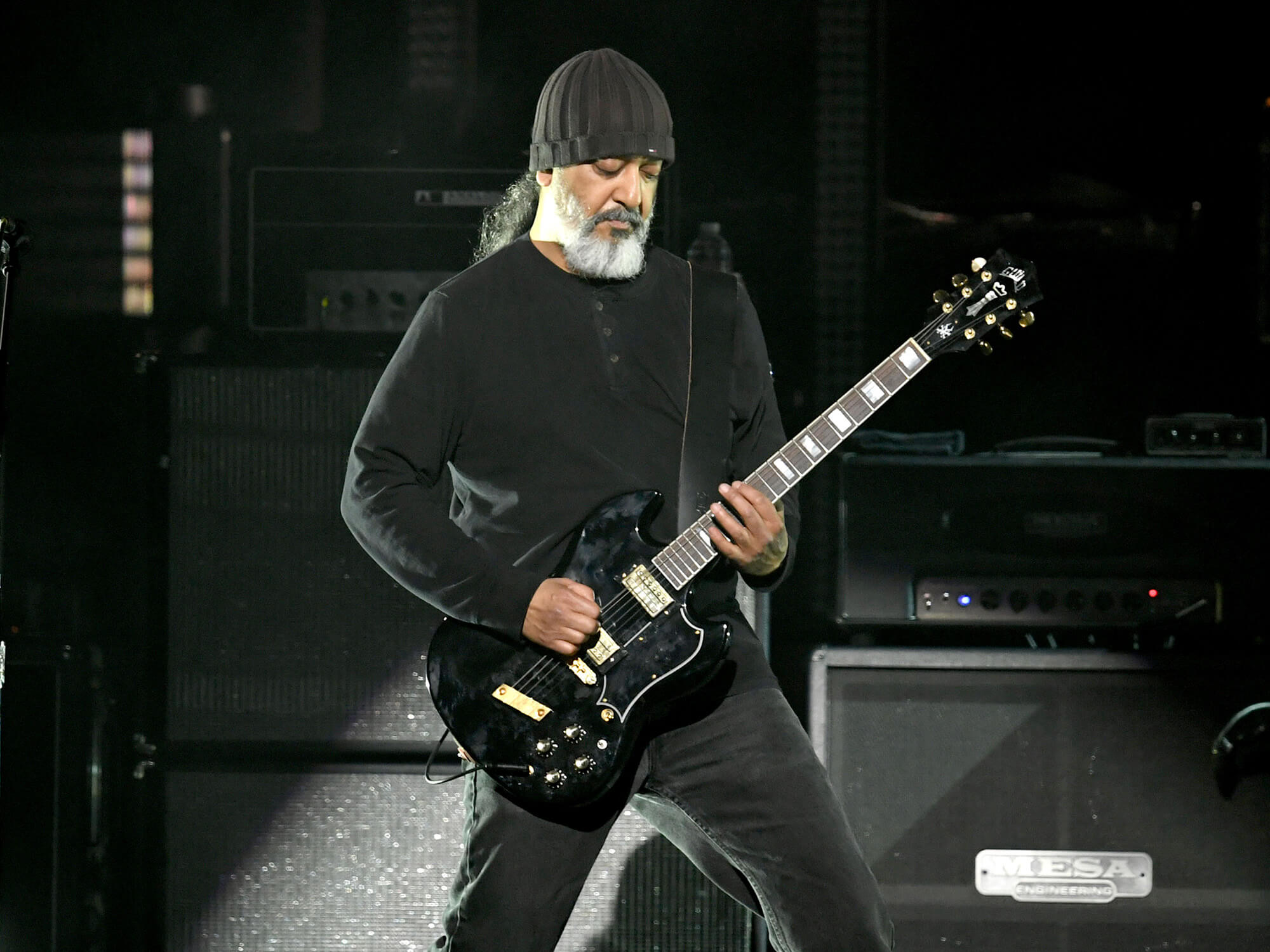 Kim Thayil on stage. He's playing a Guild guitar and is wearing all-black.