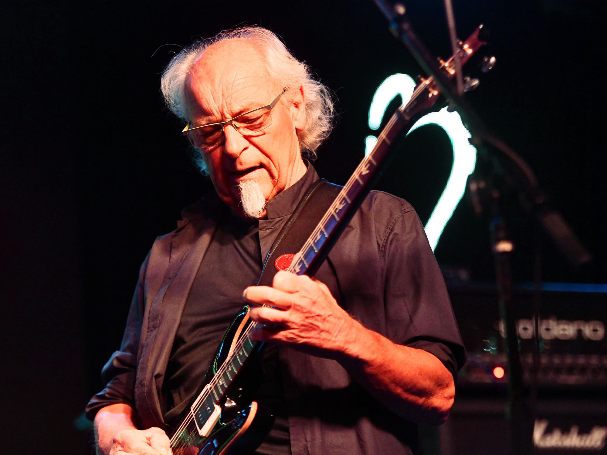 Martin Barre playing guitar on stage.
