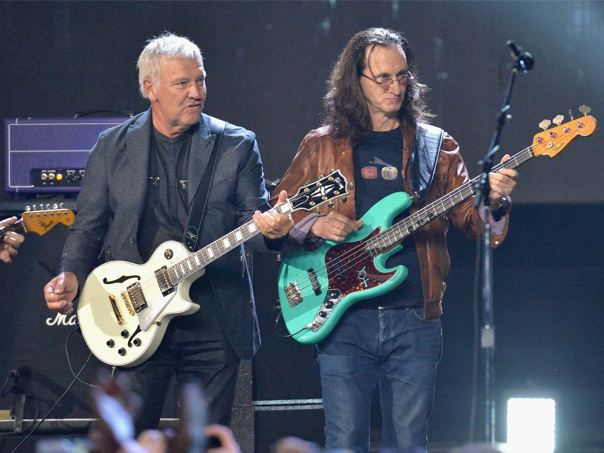 Alex Lifeson and Geddy Lee at Rock Hall. They both hold guitars in hand.
