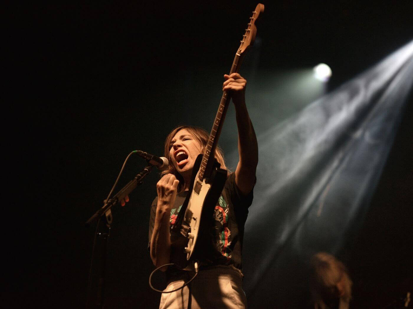 Carrie Brownstein of Sleater-Kinney performing live with a guitar, photo by Thomas Cooper/WireImage via Getty Images
