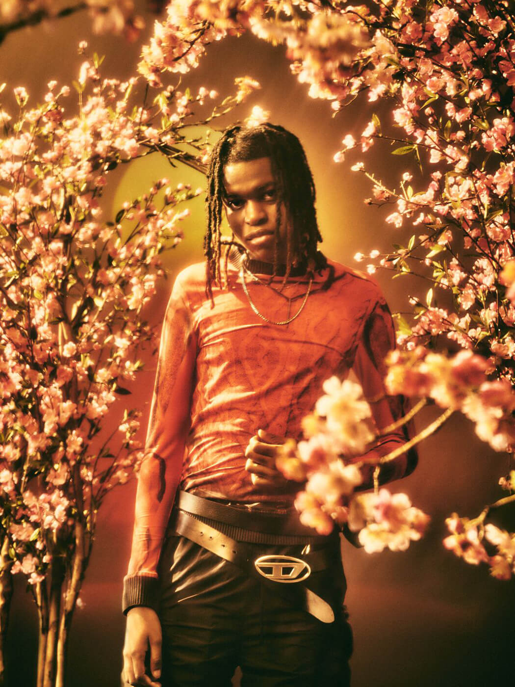 Jordan Adetunji surrounded by cherry blossoms and orange hues, photo by Frank Fieber