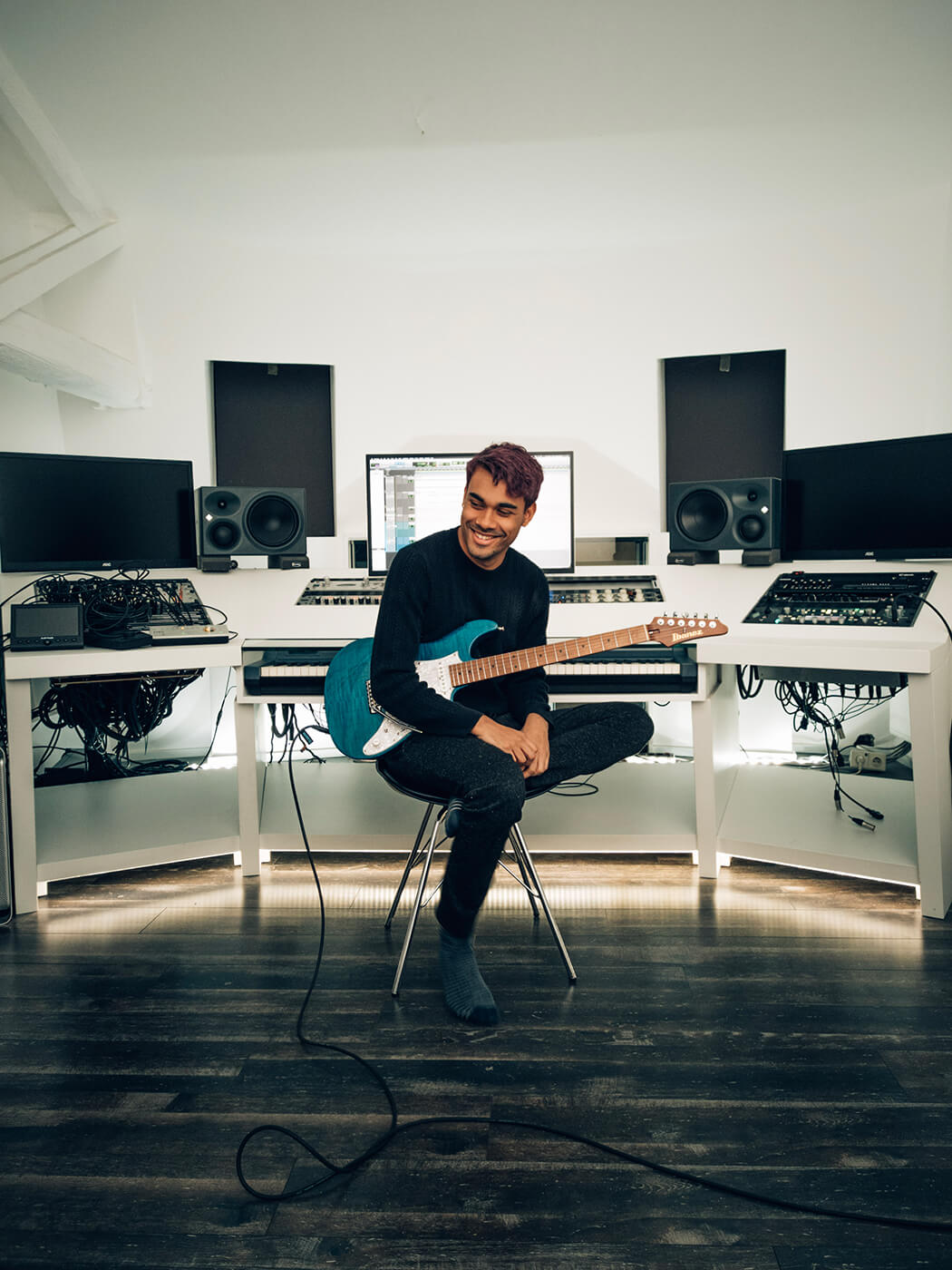Manuel Gardner Fernandes in a studio with a guitar