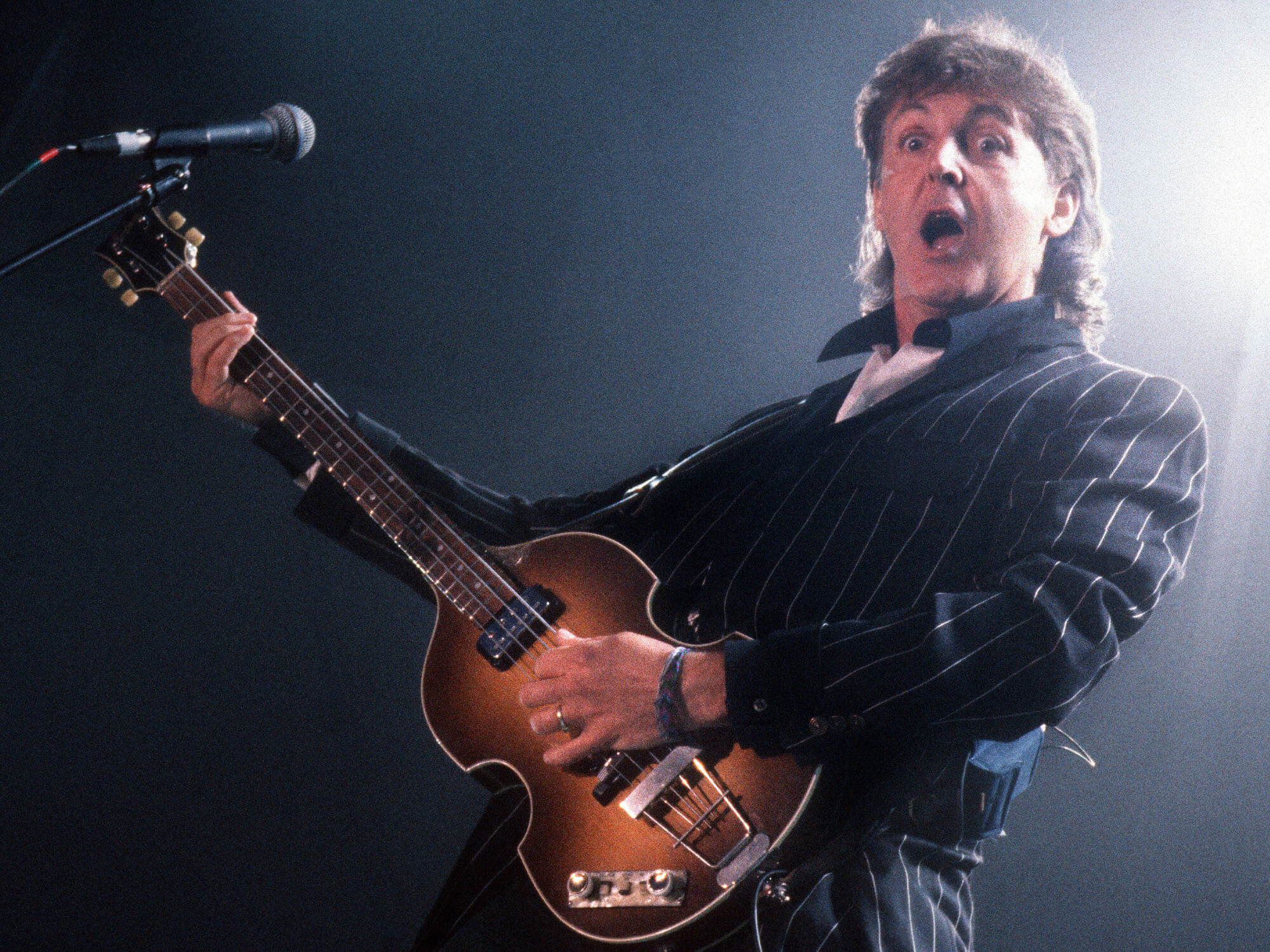 Paul McCartney performs on stage, playing Hofner 500/1 violin bass guitar