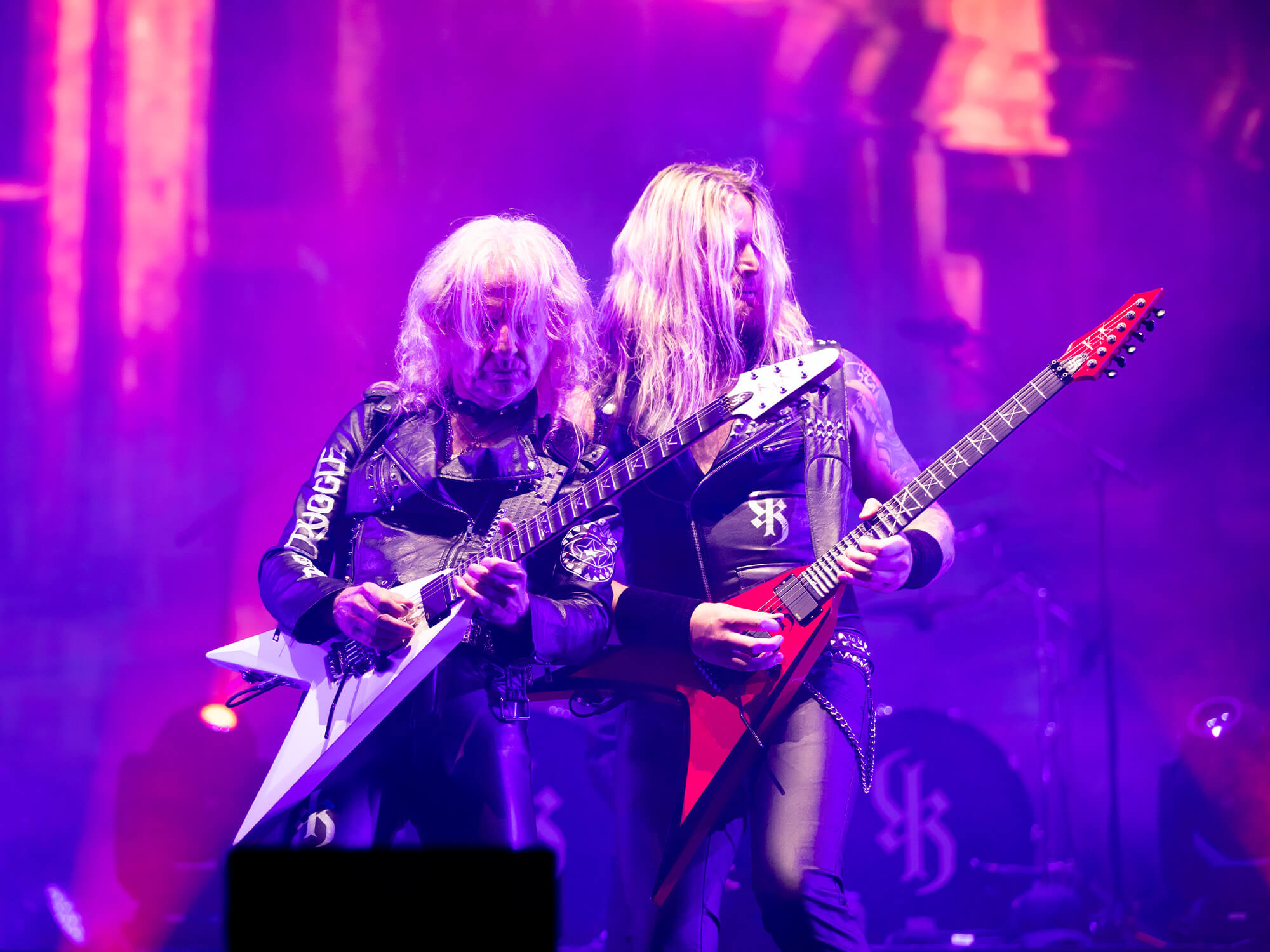 KK Downing and AJ Mills stood together playing guitar on stage