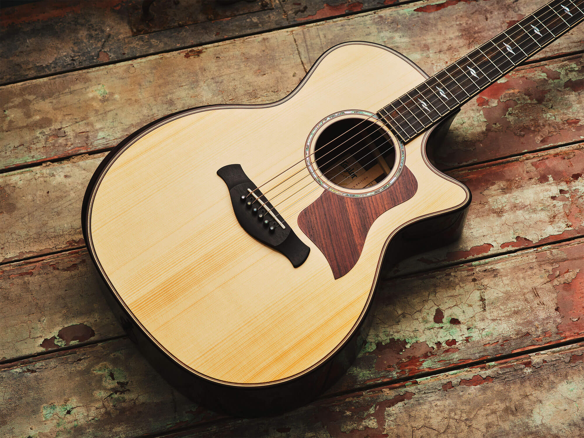 Taylor Builder's Edition acoustic laid flat on a wooden surface