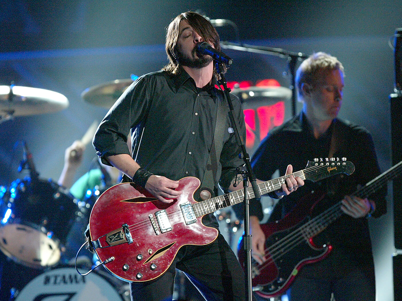 Dave Grohl performing with the Foo Fighters in 2004. He plays his red 1967 Trini Lopez signature Gibson guitar, photo by Frank Micelotta/Getty Images