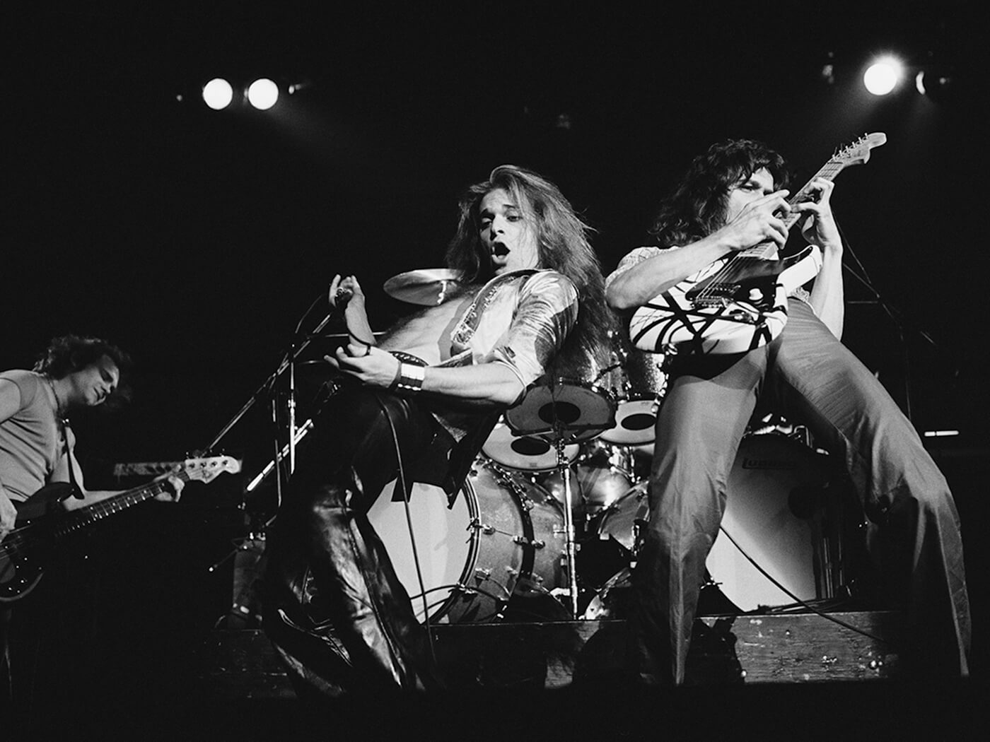 Michael Anthony, David Lee Roth and Eddie Van Halen of Van Halen performing onstage in 1978, photo by Fin Costello/Redferns via Getty Images