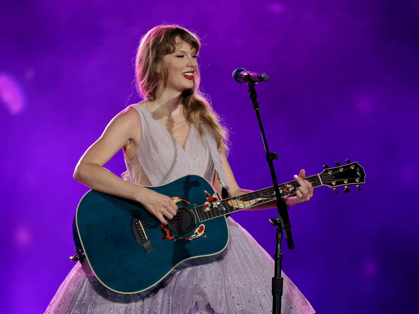 Taylor Swift performing with her blue Koi Fish Taylor guitar at the Eras Tour in Singapore, 2024, photo by Ashok Kumar/TAS24/Getty Images for TAS Rights Management