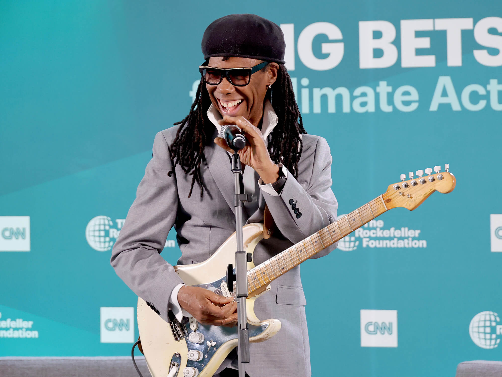 Nile Rodgers with his Hitmaker Strat. It has a shiny, reflective pick guard and a white body.