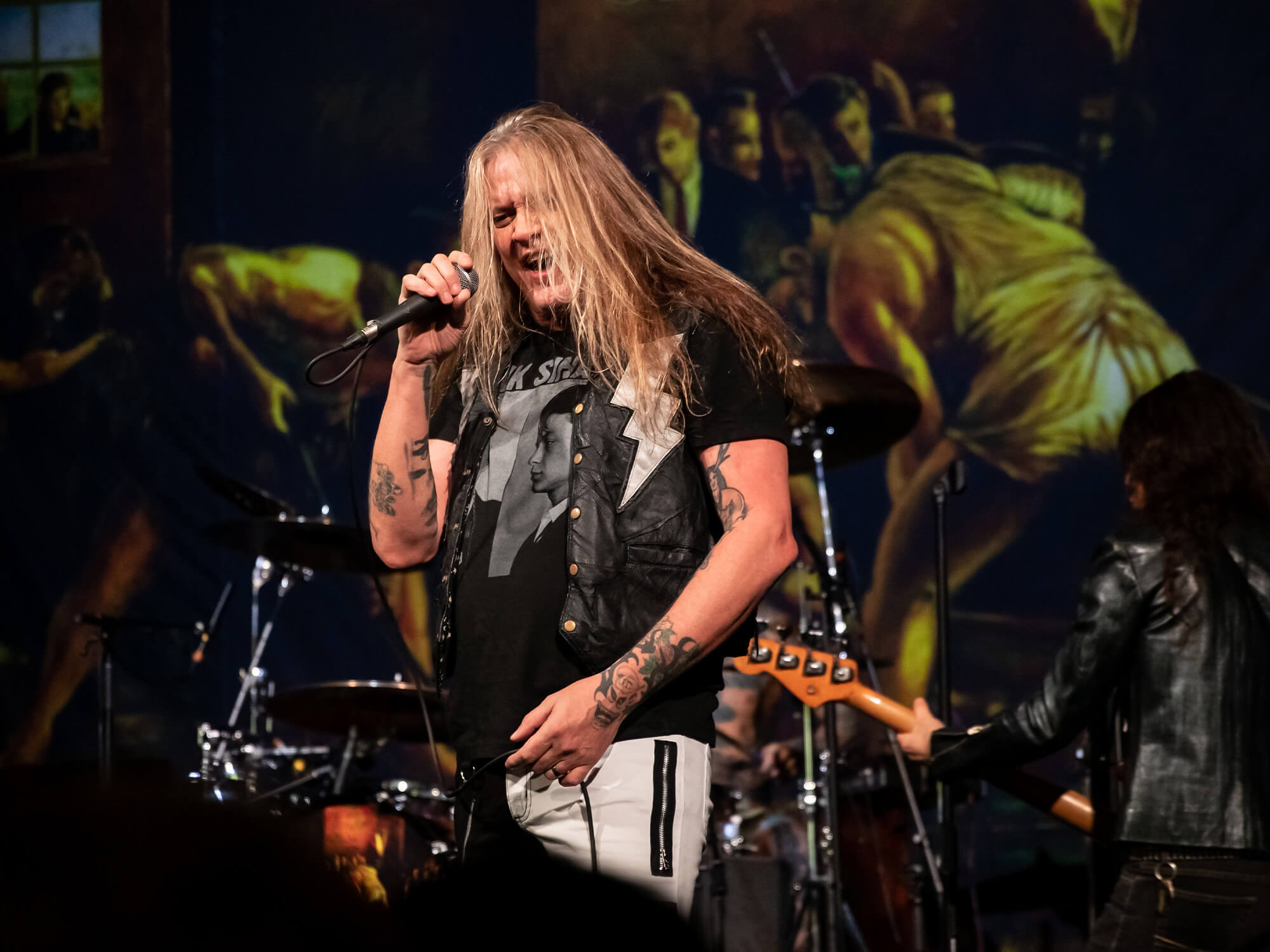 Sebastian Bach on stage singing into a mic